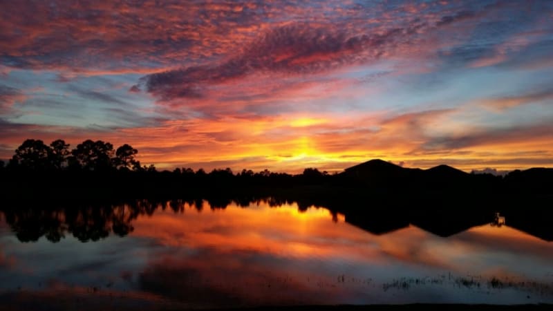 Herrliches Farbenspiel am Himmel beim abendlichen Sonnenuntergang über kleinem See